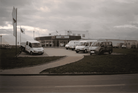 Historisches Foto des BLOHMANN-Areals mit Fahrzeugen vor dem Autohaus